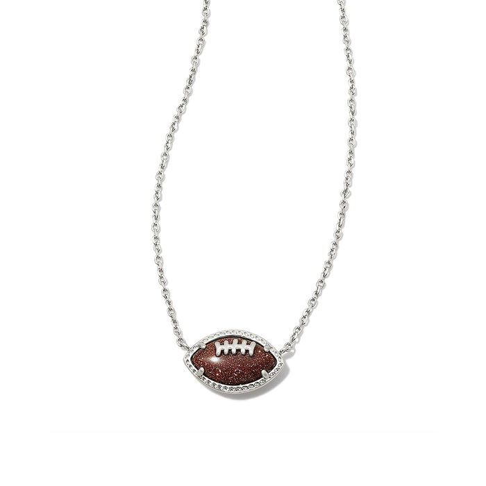 Close-up of Kendra Scott football pendant necklace featuring orange goldstone football set in silver