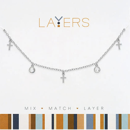 Layers silver layered necklace featuring multiple mini cross charms on polished silver-tone chains for faith-inspired everyday wear.