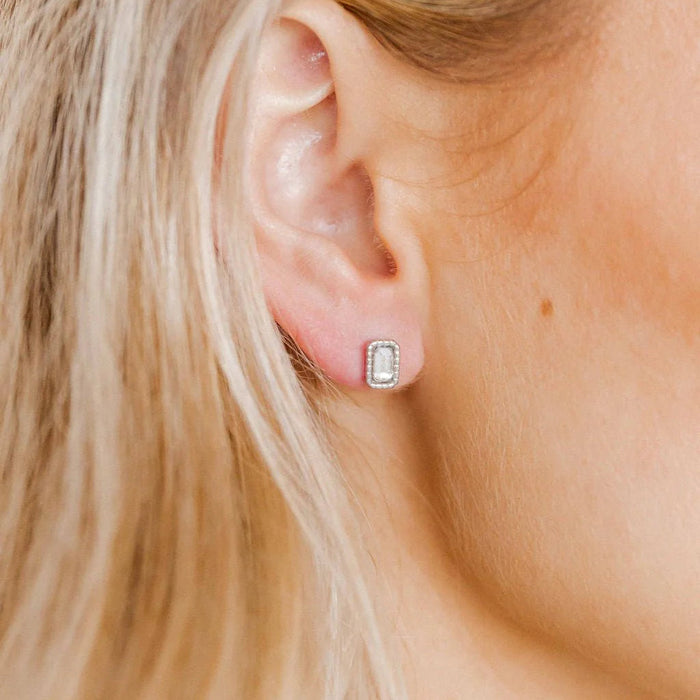 These 10mm studs feature a sleek rectangular design with a dazzling stone at the center, surrounded by a polished silver frame that adds sophistication to the look.
