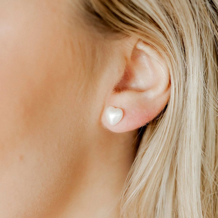  Sweet and timeless, the Lucia Small Screwback Stud Earrings feature a delicate heart-shaped synthetic pearl design that adds a soft, feminine touch to any look. 