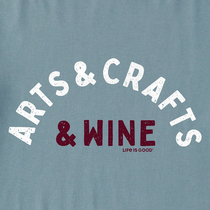 Close-up of Life Is Good Arts & Crafts & Wine graphic with distressed lettering on soft blue cotton fabric.
