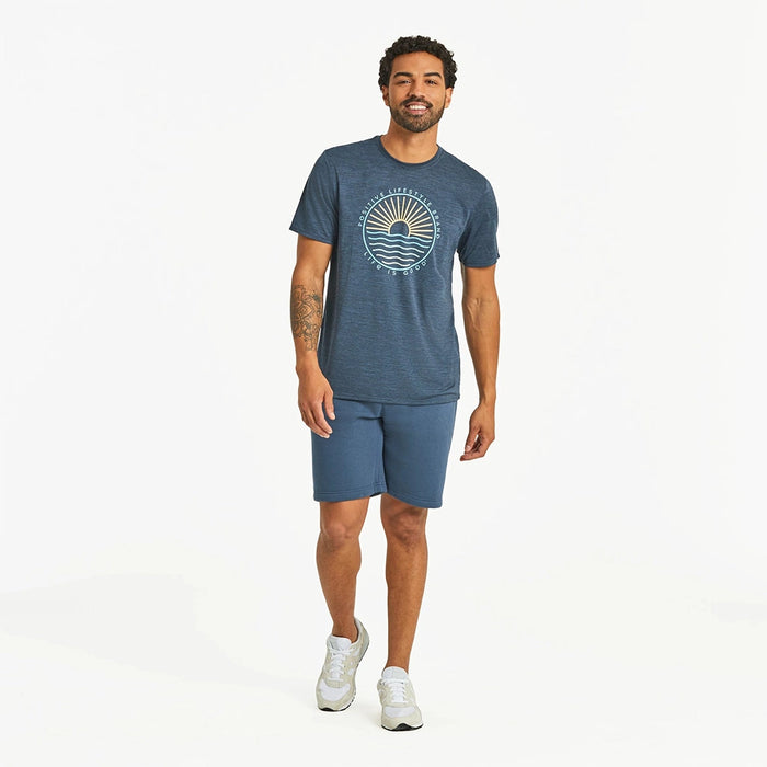 Full-body view of Life Is Good Men's Sun & Waves Crusher Tee outfit – casual men’s navy graphic tee with sun and ocean waves design, styled with shorts and sneakers.