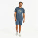 Full-body view of Life Is Good Men's Sun & Waves Crusher Tee outfit – casual men’s navy graphic tee with sun and ocean waves design, styled with shorts and sneakers.