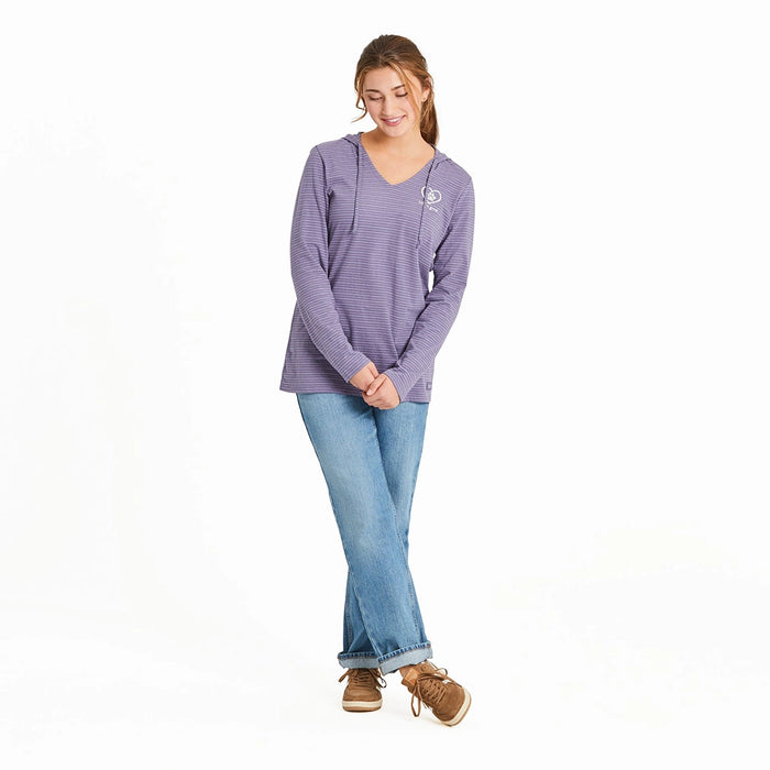 Full-body view of woman wearing Life Is Good Women’s Pet Paw Crusher Hooded Tee in purple stripes, paired with jeans