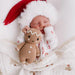 Sleeping baby in Christmas pajamas cuddling Cuddle + Kind Baby Gingerbread Doll – White Icing.