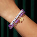 Little Words Project Fantabulous Bracelet from the Wicked collection worn on wrist with purple beads and gold charm
