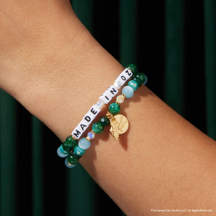 Little Words Project Made In Oz Wicked bracelet worn on wrist showing green beaded design, letter beads, and gold charm