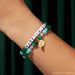 Little Words Project Made In Oz Wicked bracelet worn on wrist showing green beaded design, letter beads, and gold charm