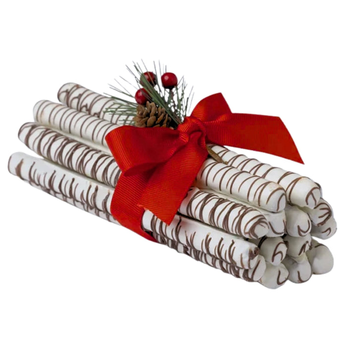 Long Grove Birch Pretzel Rods decorated with white chocolate drizzle, tied with a red ribbon and festive greenery.