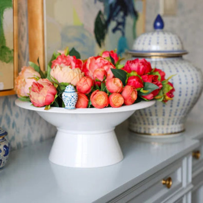 Nora Fleming White Shallow Melamine bowl on a riser Full of Fresh Tulips displayed on cabinet