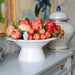 Nora Fleming White Shallow Melamine bowl on a riser Full of Fresh Tulips displayed on cabinet