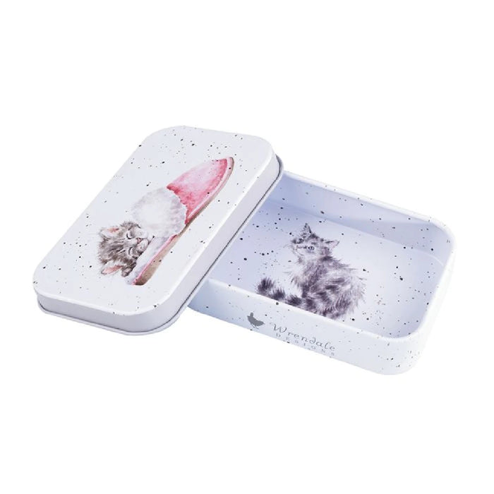 A cat peacefully sleeping inside a small tin box, with its paws tucked in and eyes closed.