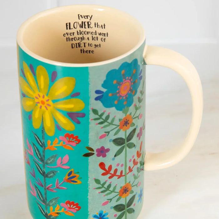 A colorful mug decorated with a lively floral pattern, highlighting a mix of vibrant flowers and artistic details.