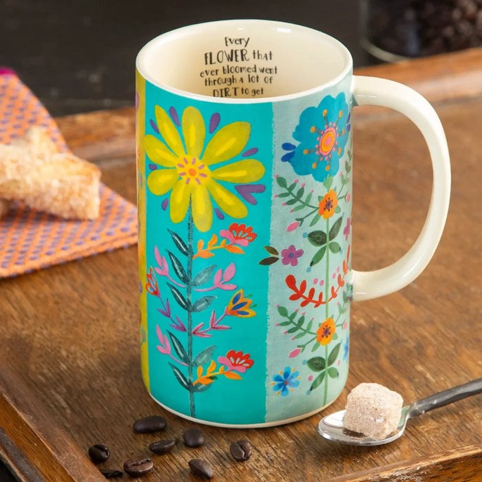 A mug featuring a colorful floral design, showcasing a variety of flowers in a bright and cheerful pattern.