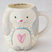 A white ceramic mug adorned with a playful bunny illustration, ideal for coffee or tea lovers.