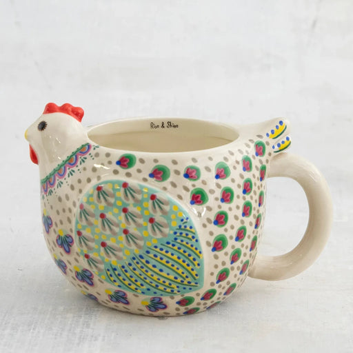 A ceramic mug featuring a vibrant, colorful chicken design on its surface.