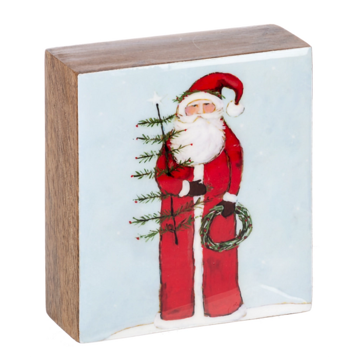 Wooden block with a Christmas-themed design featuring Santa Claus holding a tree and wreath.