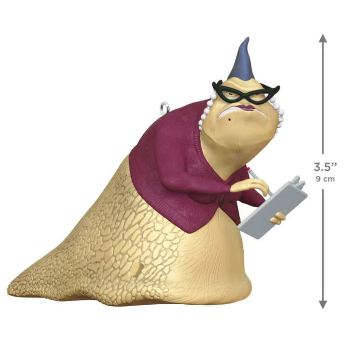 Animated character figurine with a purple scarf and eyepatch, holding a device, on a white background.