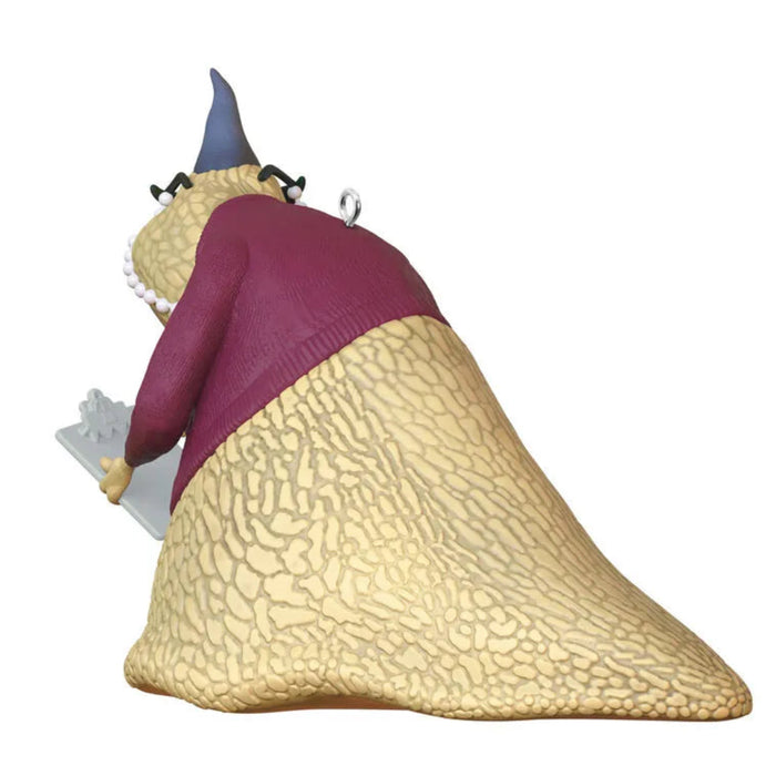 Decorative gnome figurine with a purple hat and beige body on a white background