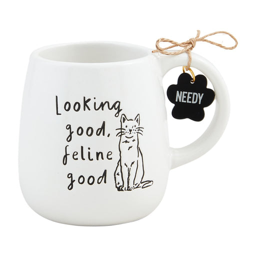 Mud Pie Feline Good Mug in white ceramic with black cat illustration and “Looking good, feline good” text, featuring a “NEEDY” paw charm tag.