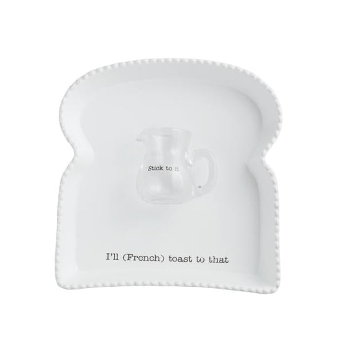 Mud Pie French Toast Platter set featuring toast-shaped ceramic plate with “I’ll (French) toast to that” text and glass syrup pitcher labeled “Stick to it.”