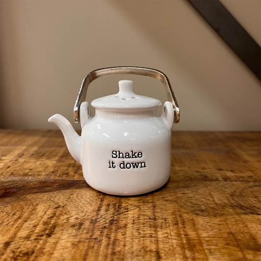 Mud Pie “Shake It Down” white ceramic shaker shaped like a teapot with a metal handle, sitting on a wooden surface.