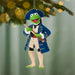 Decorative ornament of a green character in a blue coat and hat holding a rifle, hanging from a tree.