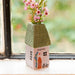 A charming house featuring a garden filled with pink flowers.