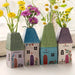 A petite house with a flourishing display of pink flowers nearby.