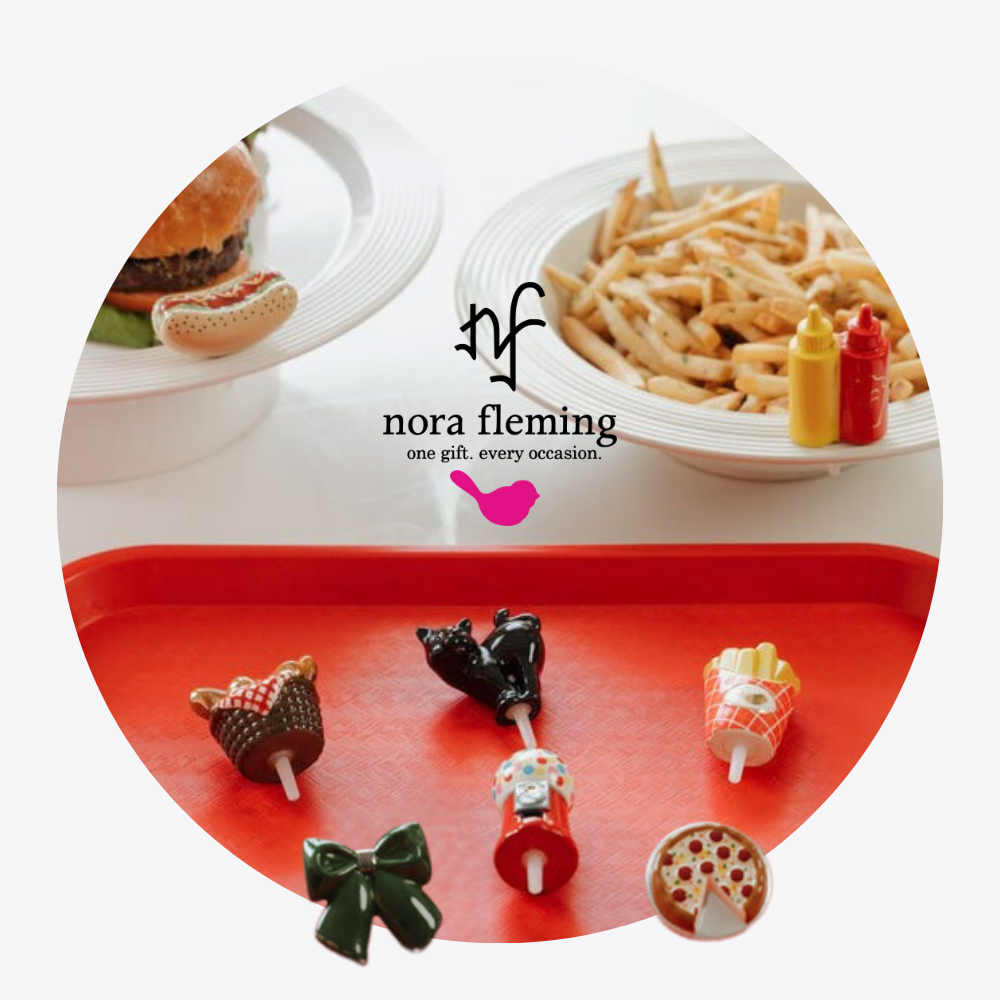 Assorted Nora Fleming minis on a red tray with 'nora Fleming' branding.