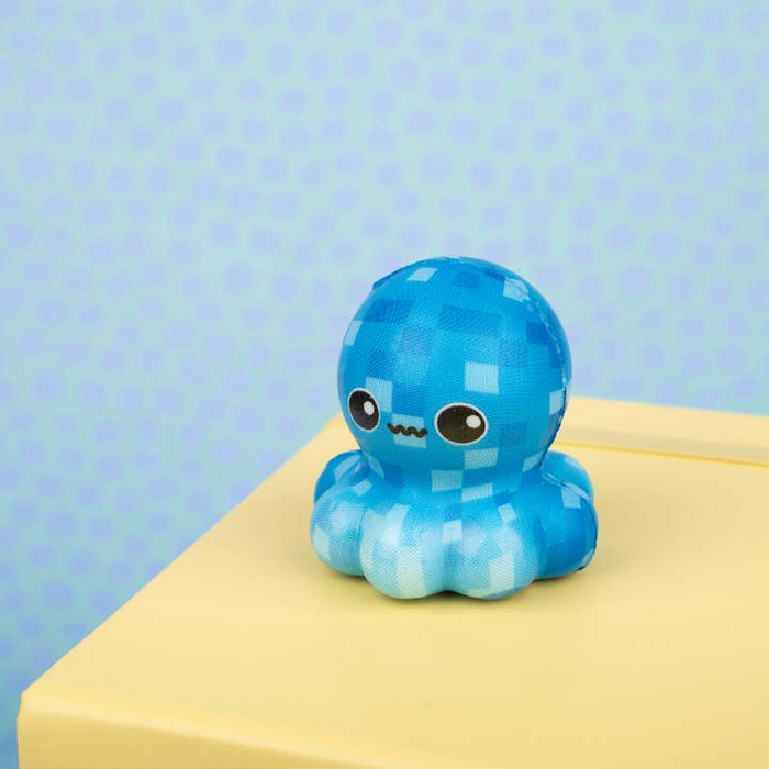 Blue checkered plush toy on a yellow surface with a light blue polka dot background