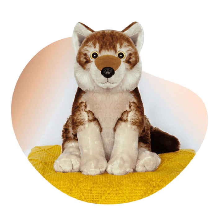 Plush toy wolf sitting on a yellow surface with a white background
