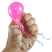 Pink squishy toy held in a hand against a white background