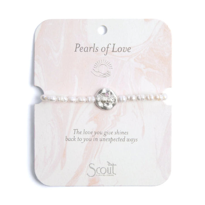 Elegant bracelet featuring lustrous pearls, symbolizing love and connection, displayed on a soft fabric background.