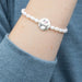 Lustrous pearl bracelet, symbolizing love, displayed artistically on a soft, contrasting background.