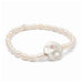 A delicate bracelet adorned with shimmering pearls, representing love, resting on a textured surface.