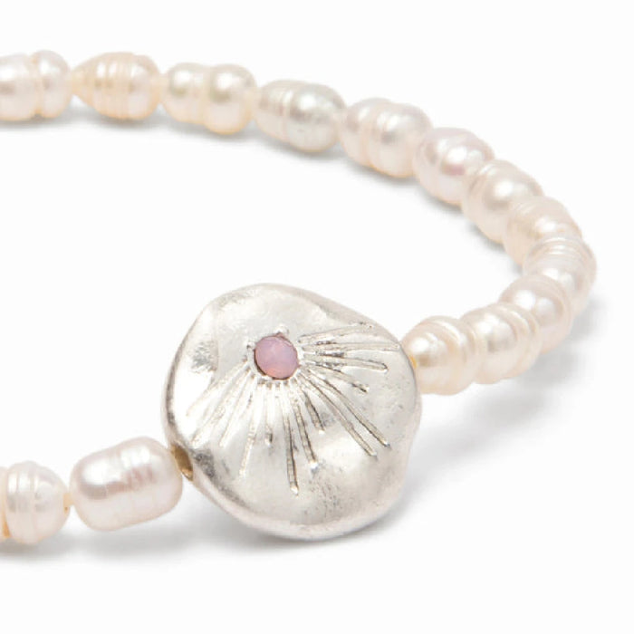 Beautiful pearls strung together in a bracelet, embodying love, showcased against a neutral backdrop.