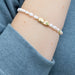 Stylish bracelet made of shimmering pearls, embodying luck, showcased against a subtle textured backdrop.