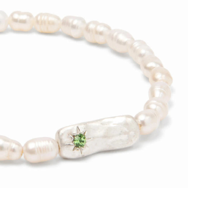 Stylish luck bracelet made of lustrous pearls, showcased against a neutral backdrop.