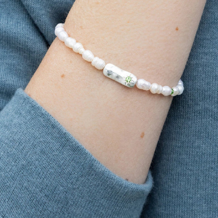 Charming bracelet with pearls, embodying luck, elegantly presented on a subtle background.