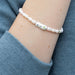 Charming bracelet with pearls, embodying luck, elegantly presented on a subtle background.