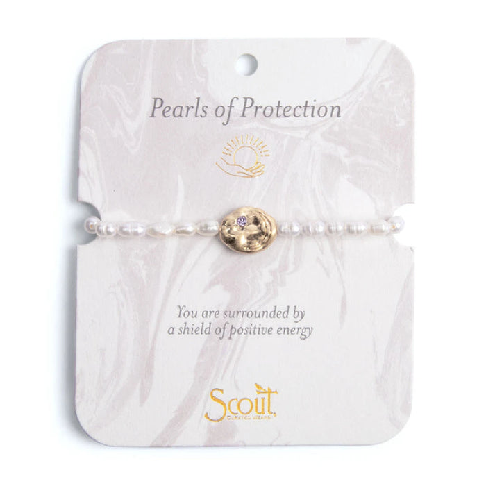 Elegant bracelet featuring pearls, symbolizing protection and beauty, displayed on a soft fabric background.