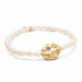 A delicate bracelet adorned with pearls, representing protection, showcased against a neutral backdrop.
