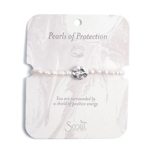 A white pearl bracelet featuring a single purple stone accent.