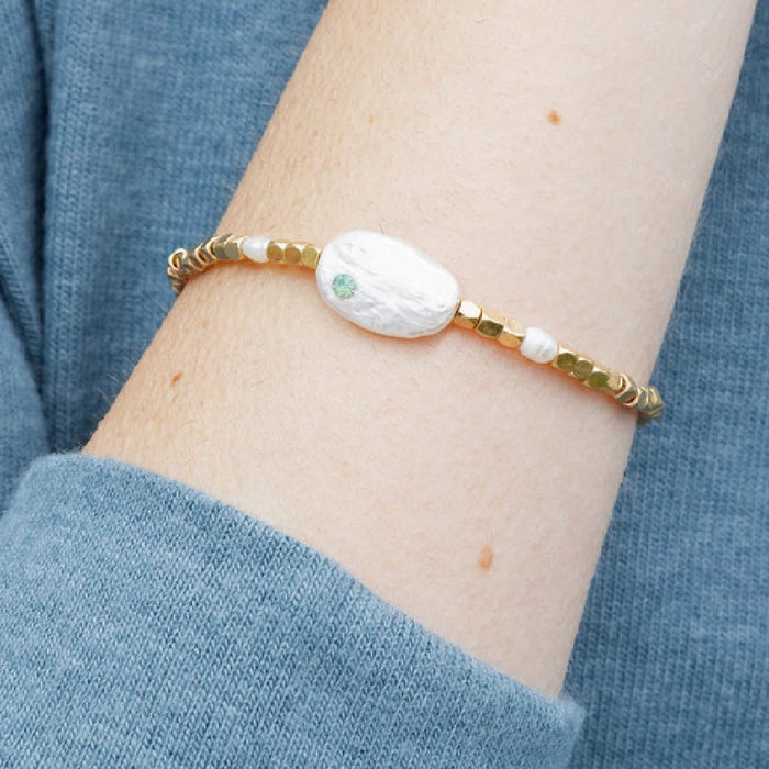 A stylish "pearls of courage" bracelet featuring gleaming pearls, representing strength and elegance in a refined accessory.