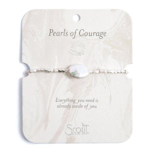 A white pearl bracelet adorned with green stones, showcasing an elegant and sophisticated design.