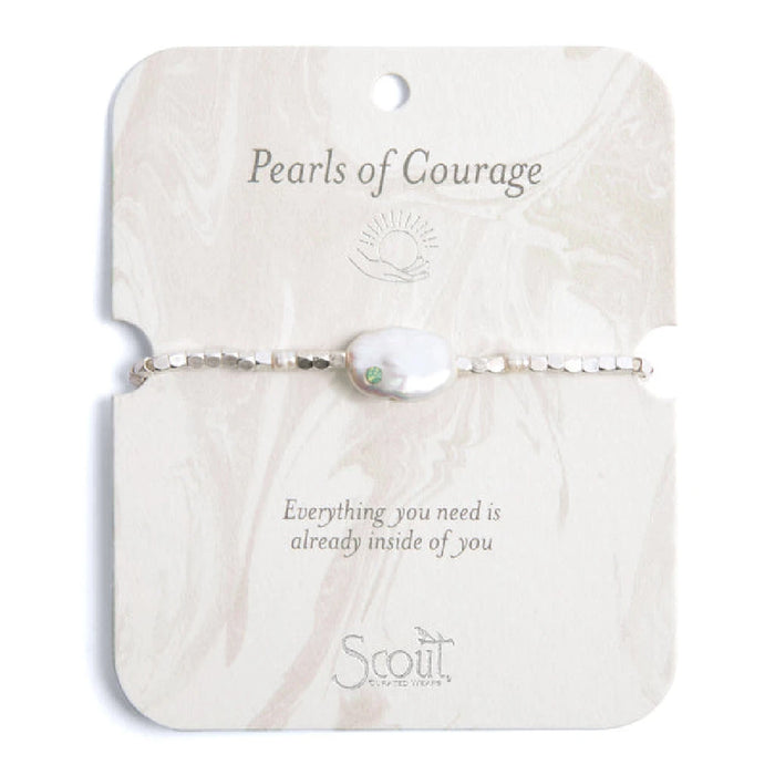 A white pearl bracelet adorned with green stones, showcasing an elegant and sophisticated design.
