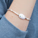 A delicate bracelet composed of white pearls and green stones, combining classic and modern elements beautifully.