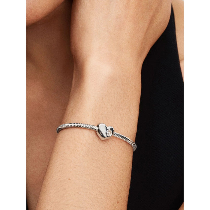 Model wearing the silver bracelet with the clear stone heart charm, styled simply for an elegant everyday look.