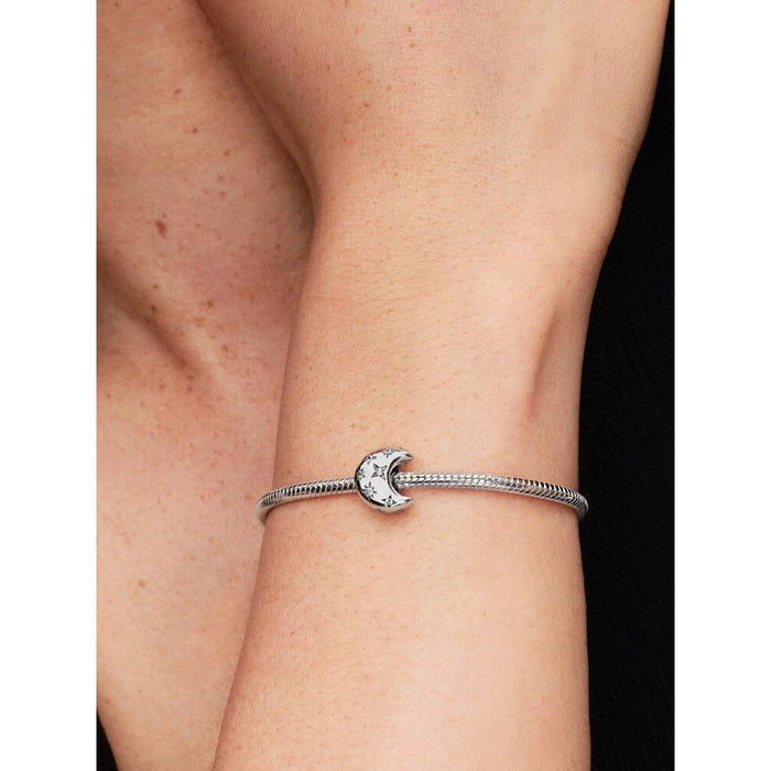 Pandora Crescent Moon Charm styled on a bracelet worn on a woman’s wrist.
